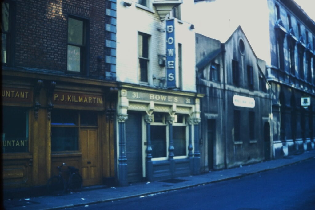 A row of buildings. First is PJ Kilmartin, and I think the rest of the sign says "accountant" but not sure. Next is Bowes, #31 (the address). The next building's sign isn't legible